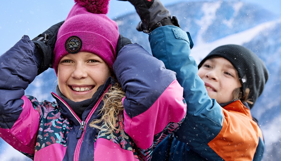 Children smiling in the snow gear
