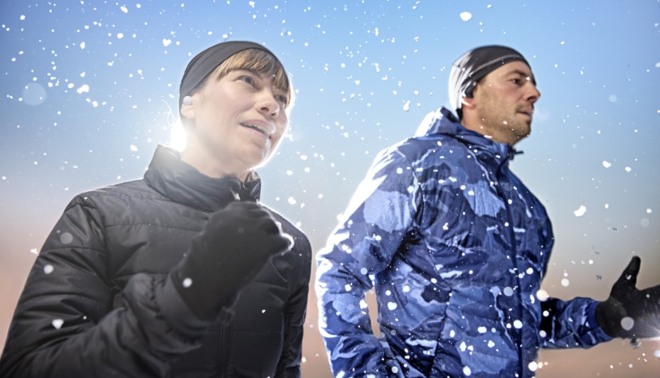 Man and woman embrace the hill with ski and snowboard gear